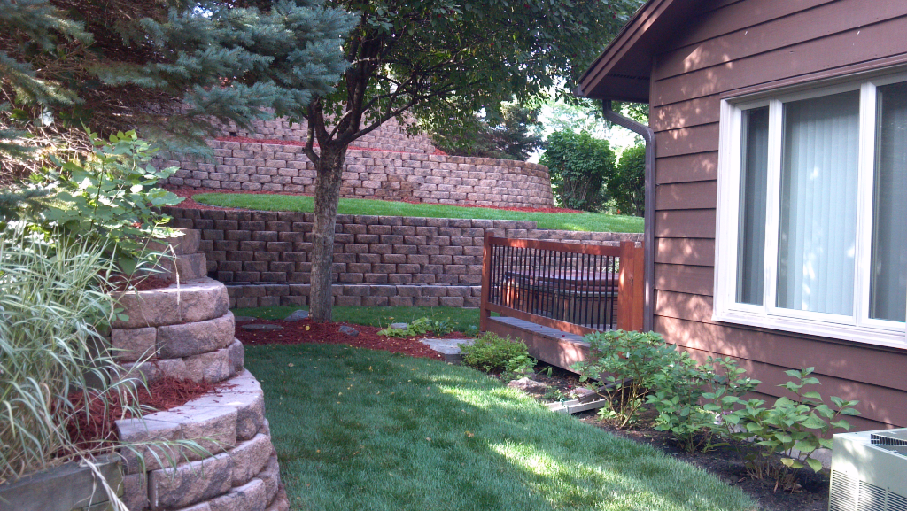 Backyard renovation landscaping with brick retaining wall