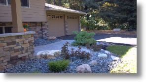 front entry with brick pavers, planting and boulder outcroppings