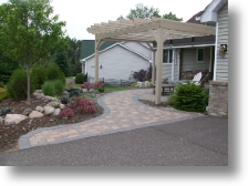 front entry with brick pavers, boulder walls and bubbling boulder fountian and entry arbor