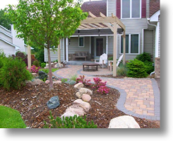 entry with brick pavers, boulders, fountian, and arbor